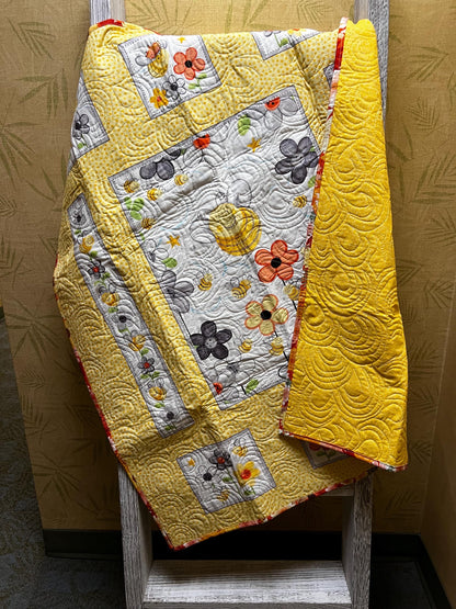 Handmade quilted baby blanket with bumblebees, flowers and yellow background