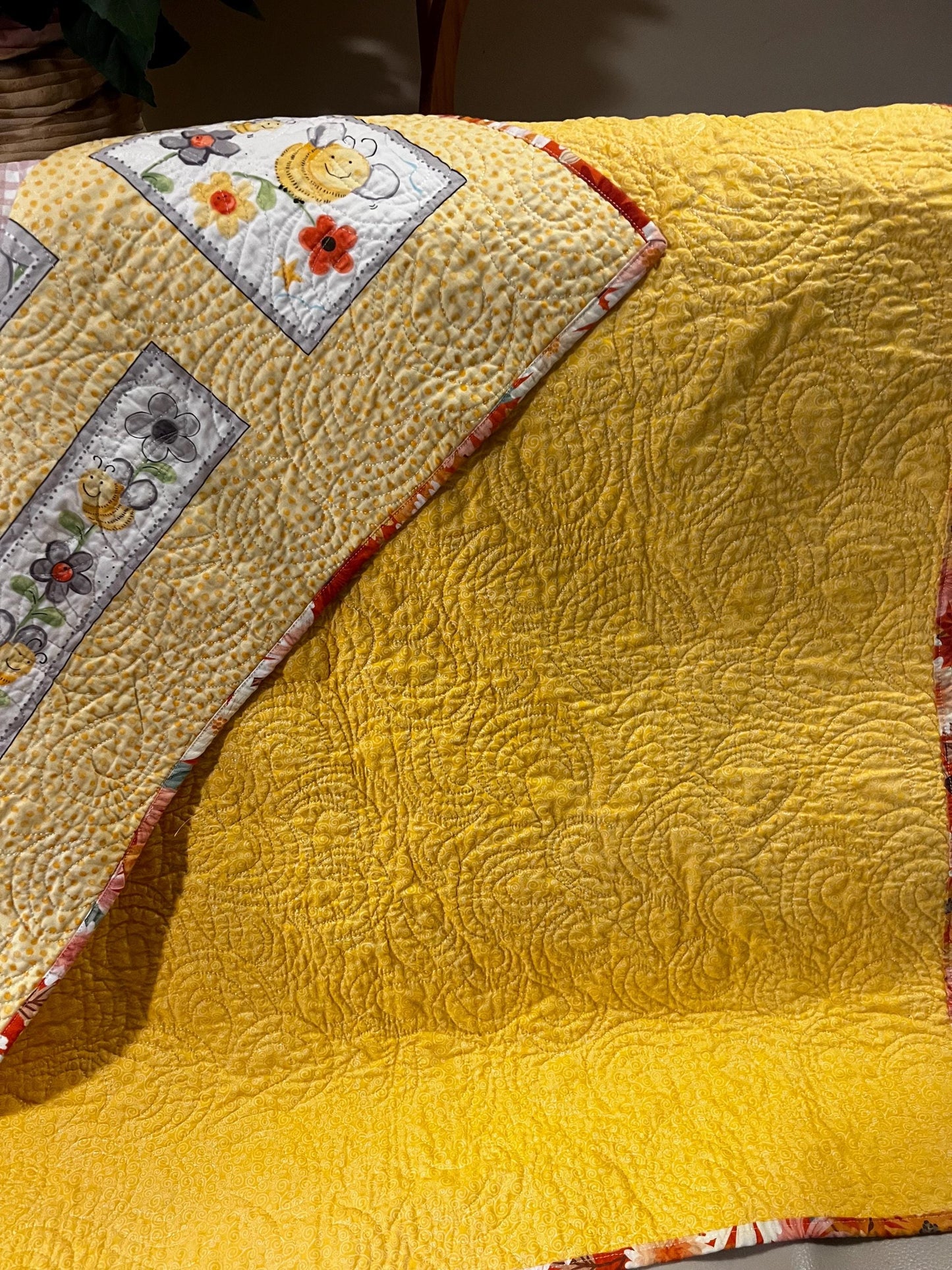 Handmade quilted baby blanket with bumblebees, flowers and yellow background